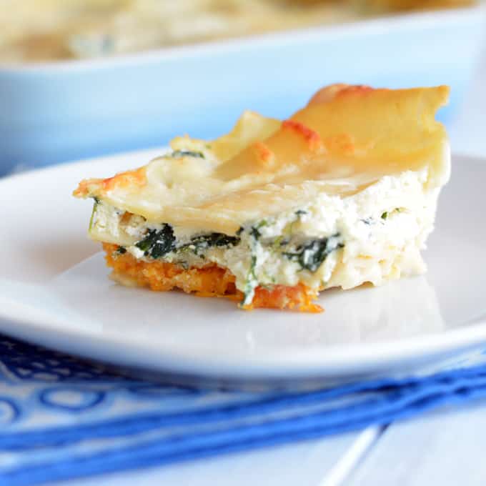 A slice of creamy three-cheese Butternut squash lasagna on a white plate.