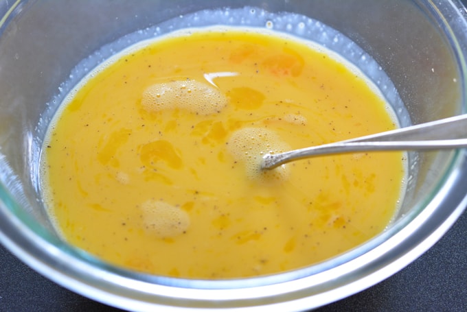 Beaten eggs in glass bowl.