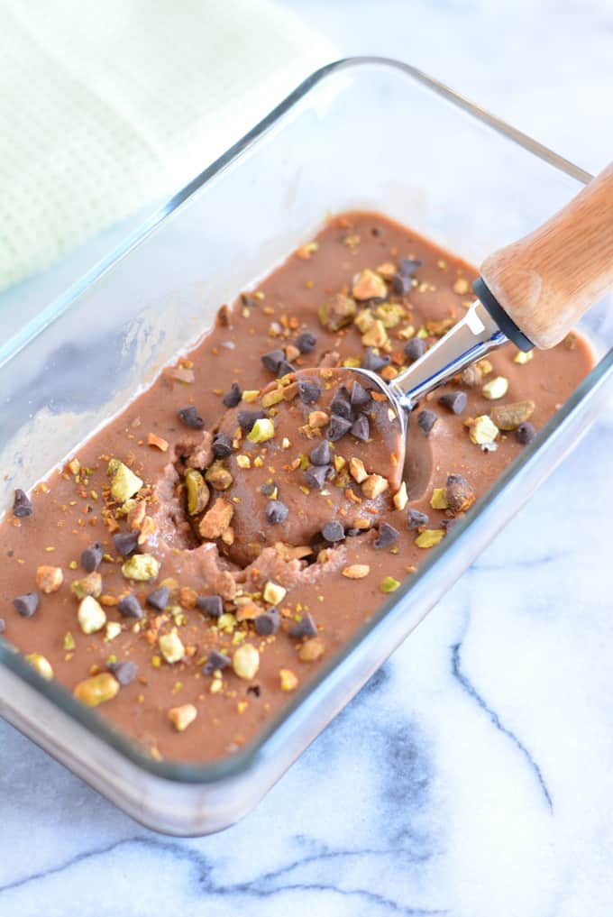 Homemade chocolate pistachio chip nice cream in a glass dish