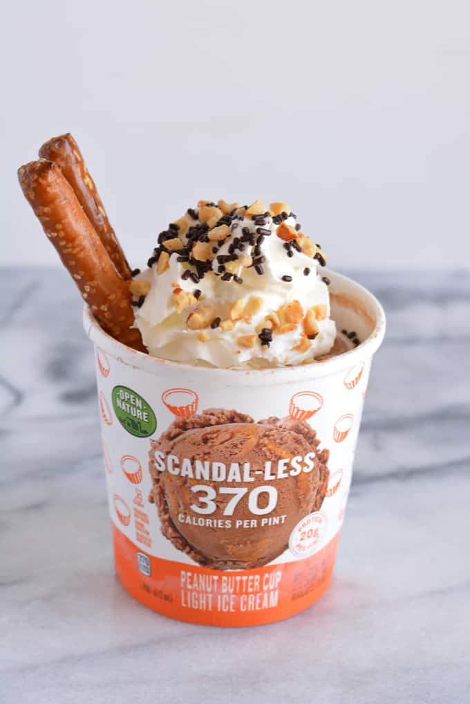 Scandal-less ice cream pint topped with whipped cream, chocolate jimmies, and pretzel rods.